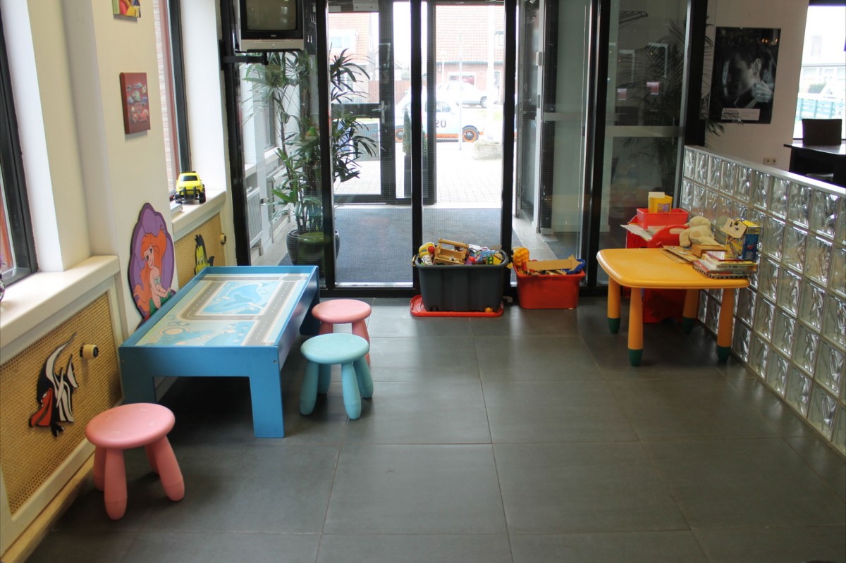 De speelhoek voor kinderen in de salon, met speelgoed en een zithoekje.